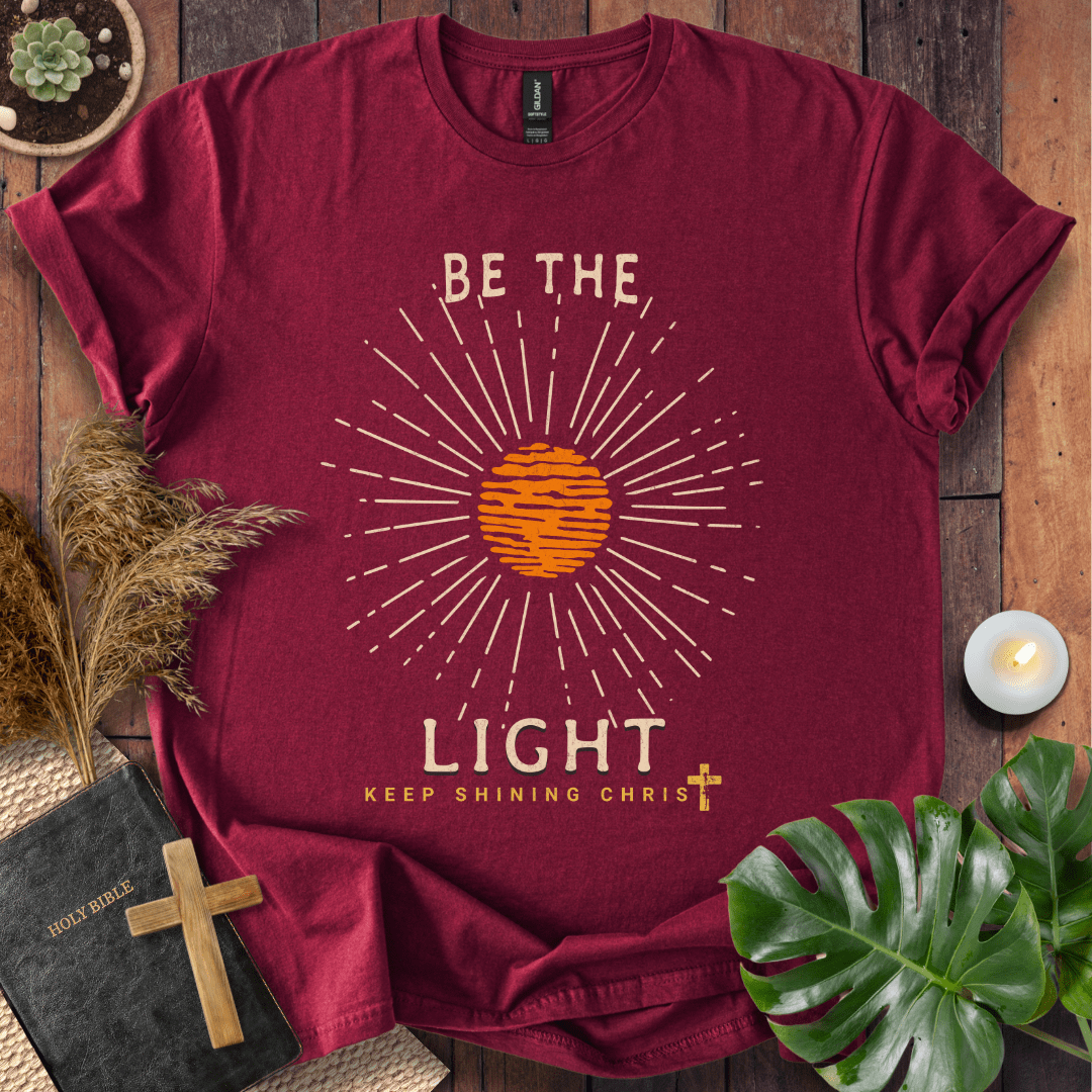 Be the Light Christian t-shirt—radiant sunburst with “Keep Shining Christ,” inspired by Matthew 5:14–16.
