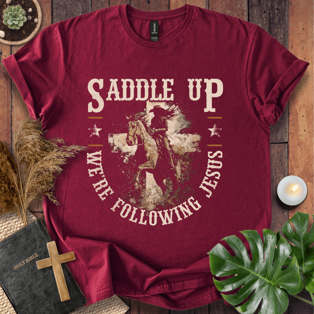t-shirt featuring a horse and rider silhouette on a cross with text Saddle Up We're Following Jesus in a vintage style.