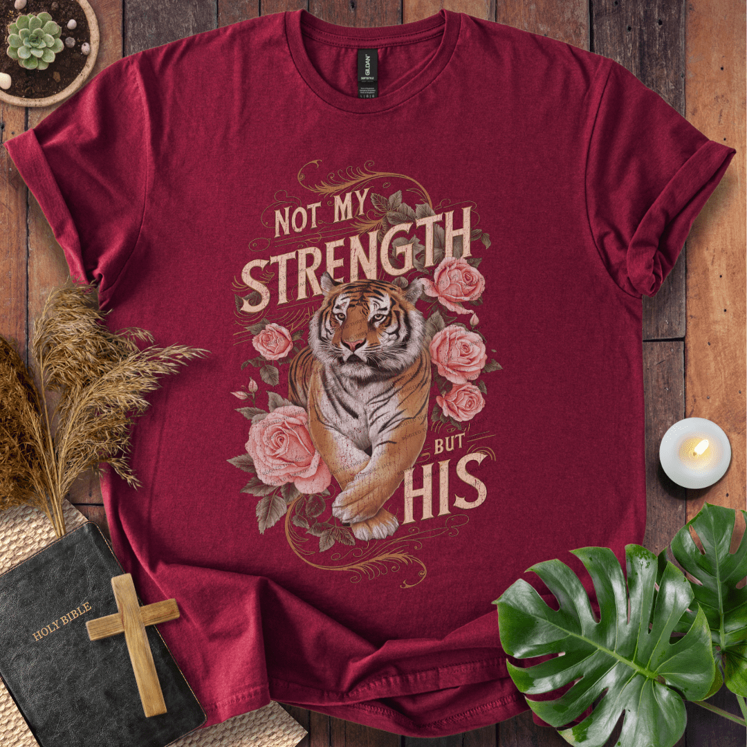 Not My Strength But His Christian t-shirt in black—tiger with roses and vintage script faith design.