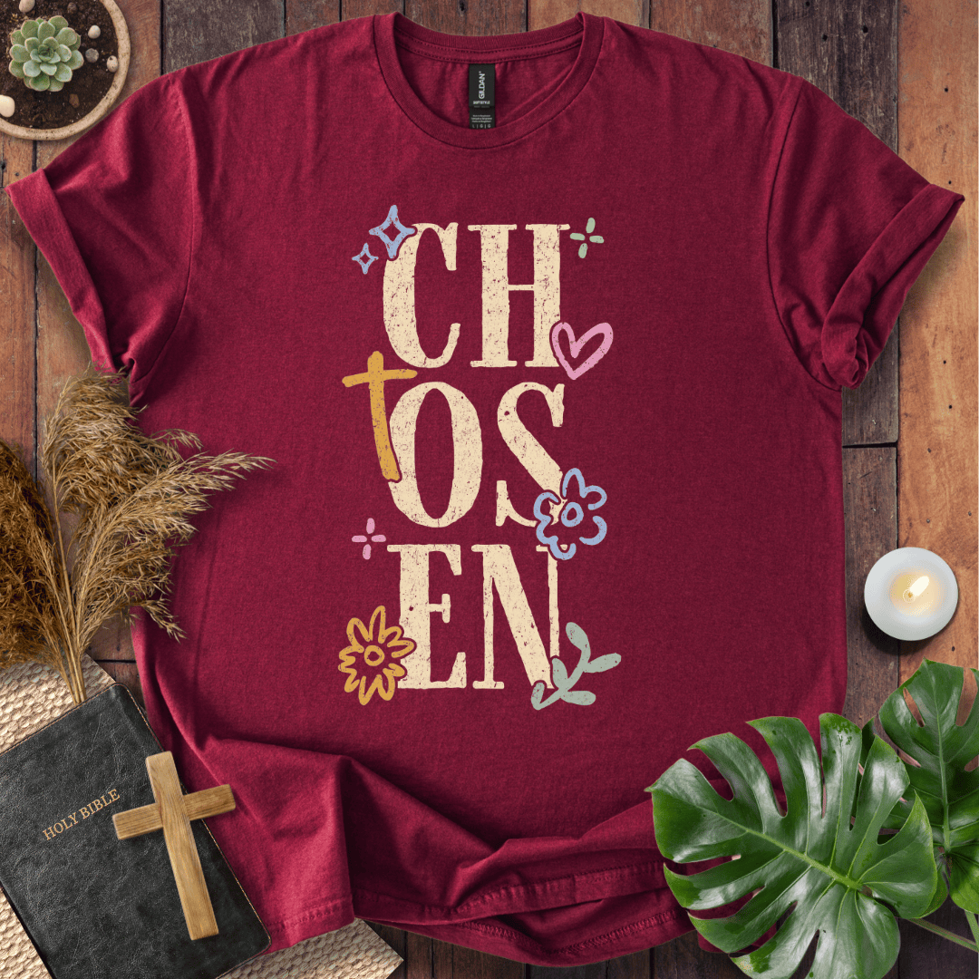 Distressed "CHOSEN" graphic on a t-shirt with a rustic gold cross and colorful boho wildflowers.
