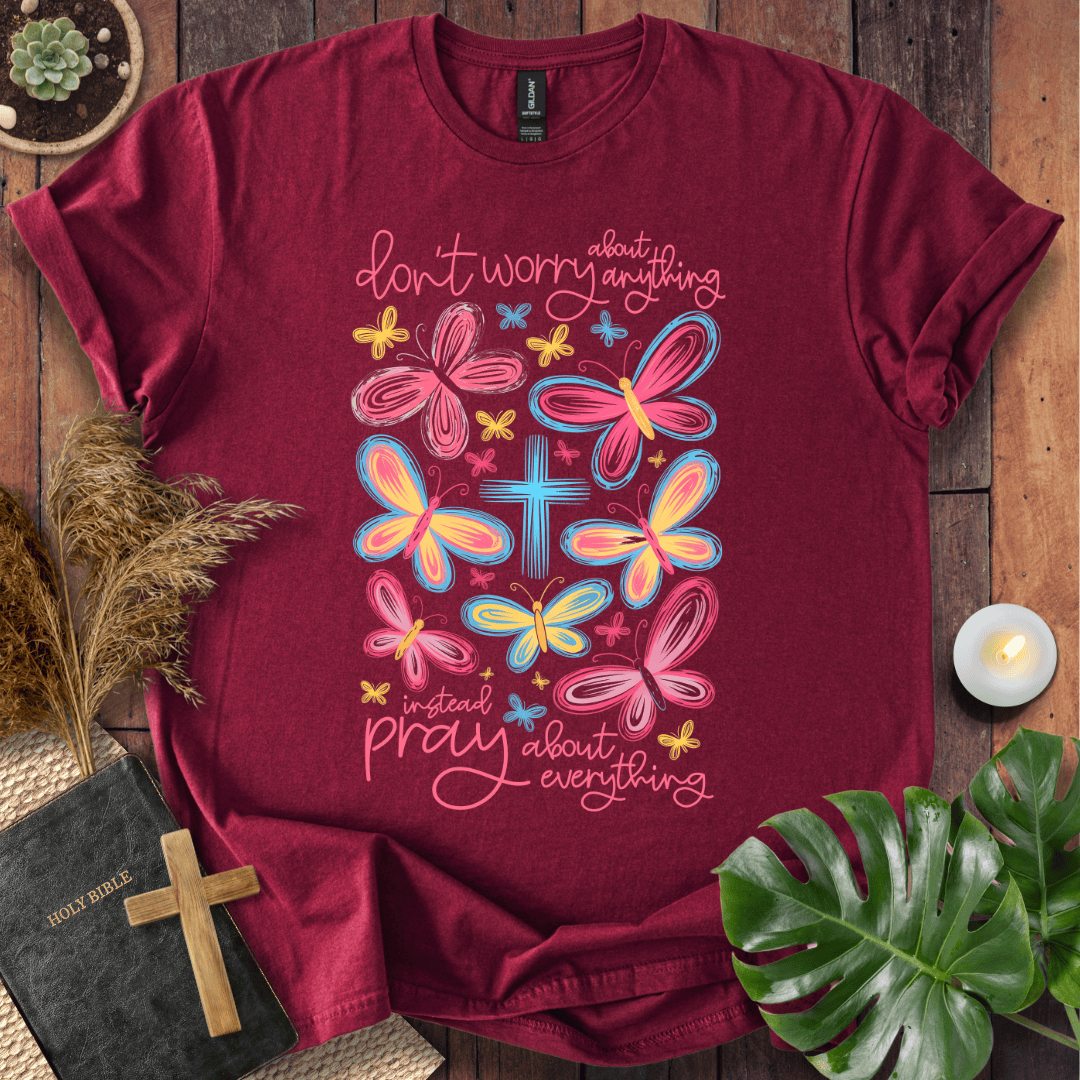 butterfly faith shirt with a Bible and cross on a rustic wooden background.