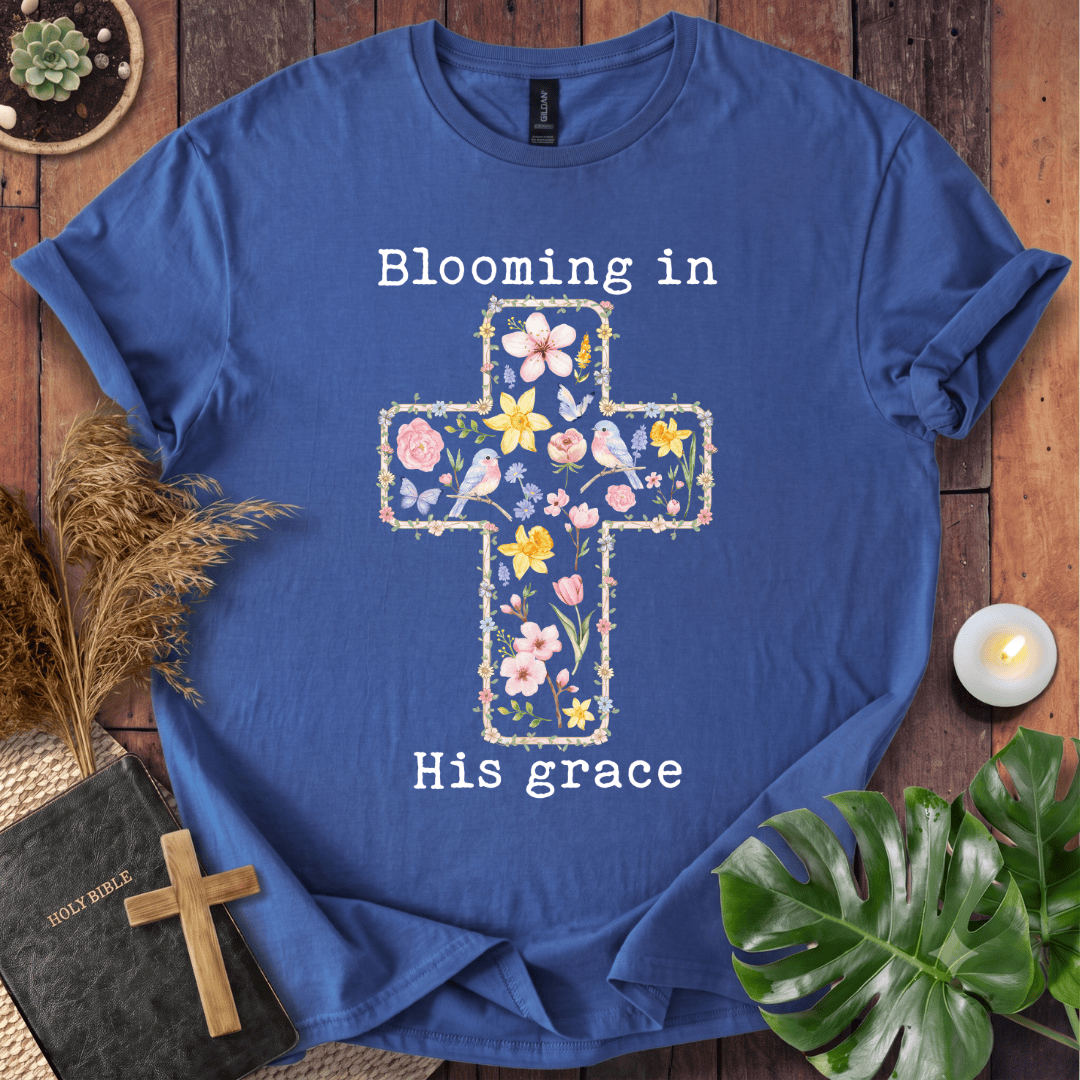 t-shirt featuring a cross filled with colorful wildflowers and birds, with the text "Blooming in His grace".