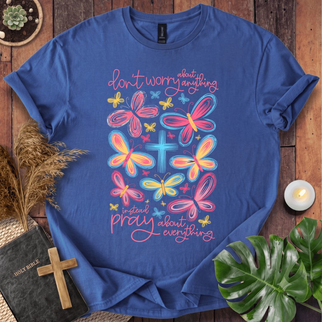 butterfly faith shirt with a Bible and cross on a rustic wooden background.
