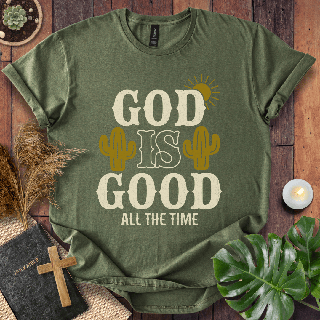 God Is Good All The Time t-shirt with cacti and sun graphics, styled with a Bible and wooden cross.