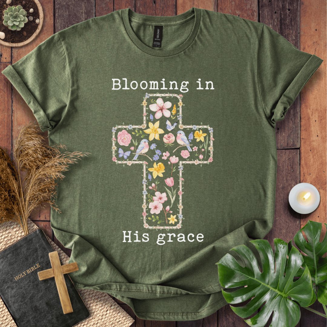 t-shirt featuring a cross filled with colorful wildflowers and birds, with the text "Blooming in His grace".