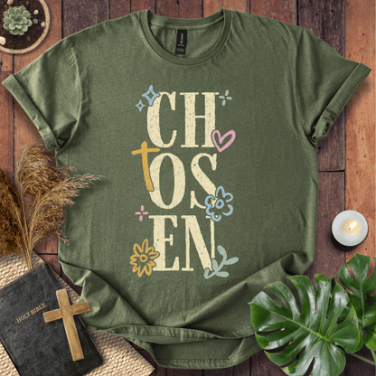Distressed "CHOSEN" graphic on a t-shirt with a rustic gold cross and colorful boho wildflowers.