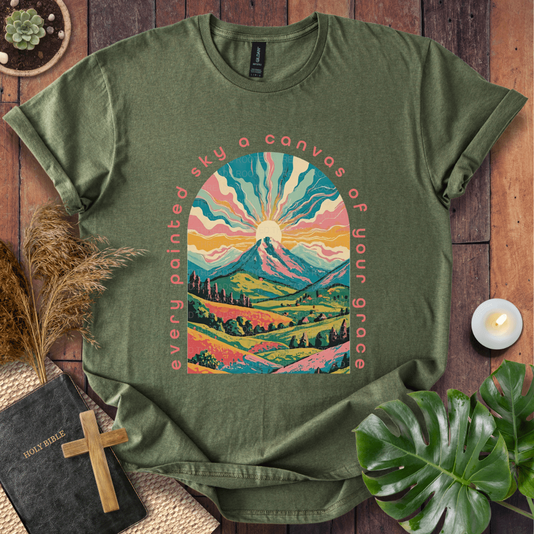 “Every painted sky a canvas of Your grace” Christian t-shirt—arched mountain sunrise with rays, rolling hills, floral accents.