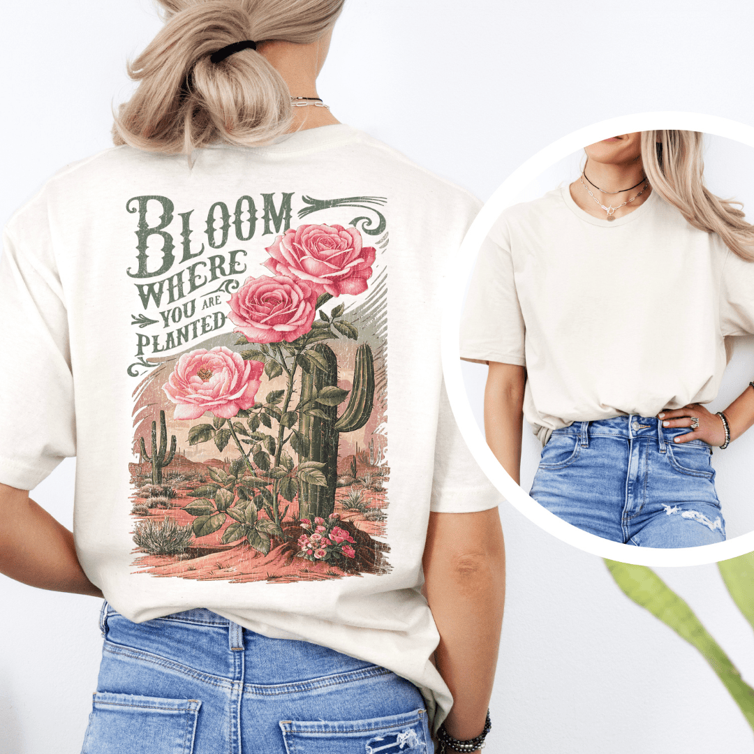 Back of a t-shirt featuring pink roses, green saguaro cacti, and text reading Bloom Where You Are Planted.