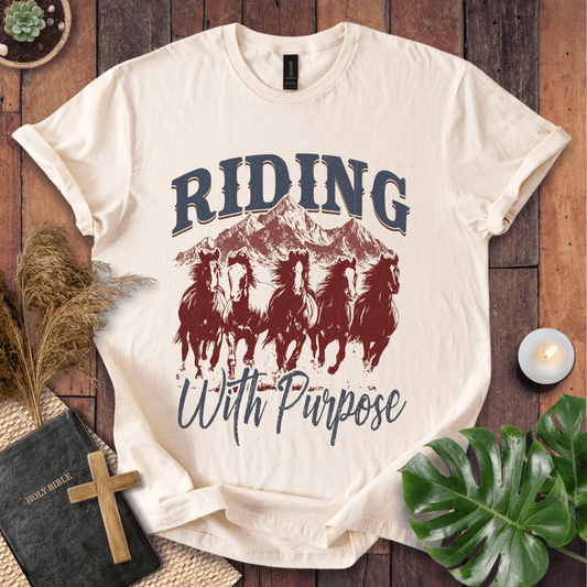 t-shirt with navy and rust graphic of five running horses, mountains, and "Riding With Purpose" vintage text.