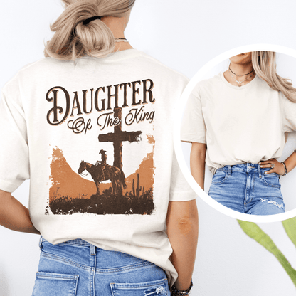 A woman wearing a graphic t-shirt with a western desert cross, cowboy on a horse, and Daughter of the King text.