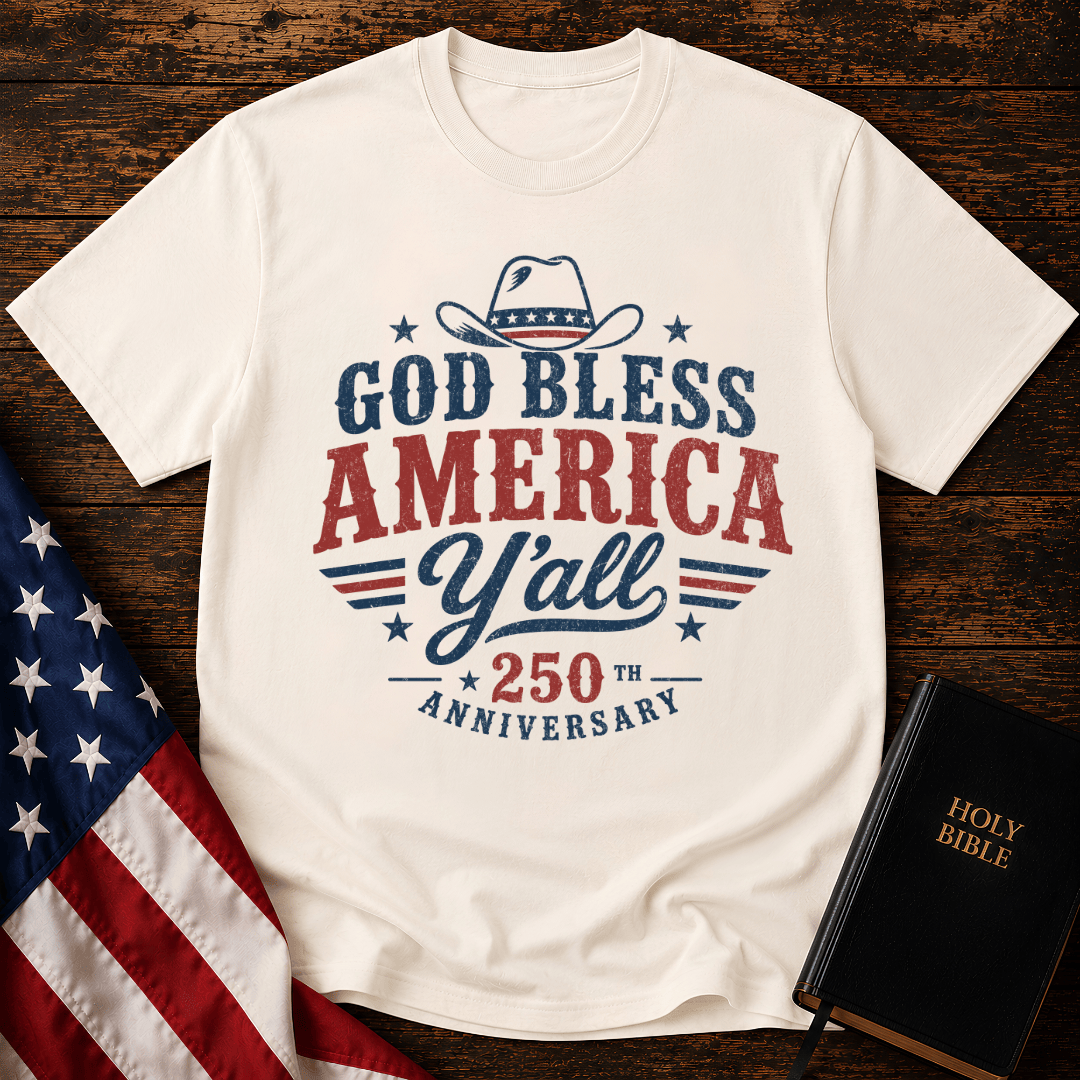 Christian t shirts featuring a Western cowboy hat, USA flag details, and God Bless America Y'all text on wood.