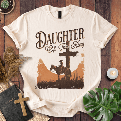 Western Christian t shirt for women featuring a rider on a horse by a cross in a desert sunset.
