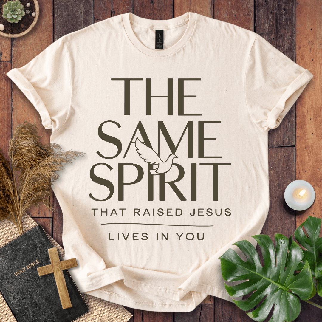 Easter Christian t-shirt with "The Same Spirit That Raised Jesus Lives In You" text and dove icon on wooden background.