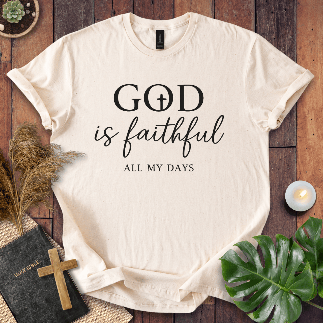 Christian t-shirt reading "God is Faithful All My Days" on a rustic wood background with a Bible and cross.