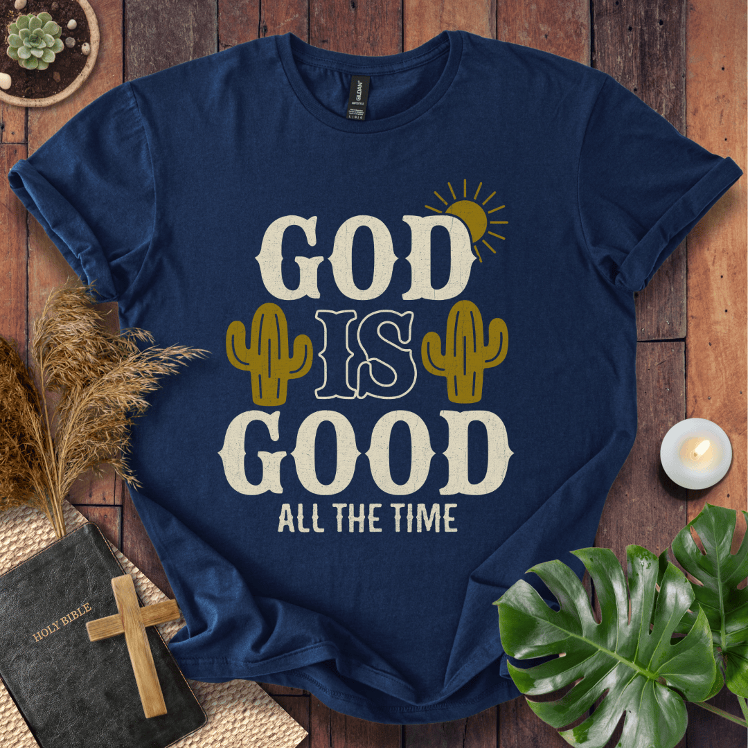 God Is Good All The Time t-shirt with cacti and sun graphics, styled with a Bible and wooden cross.