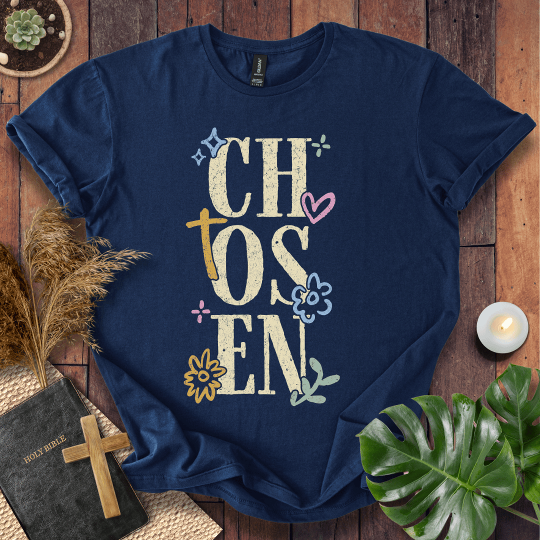 Distressed "CHOSEN" graphic on a t-shirt with a rustic gold cross and colorful boho wildflowers.