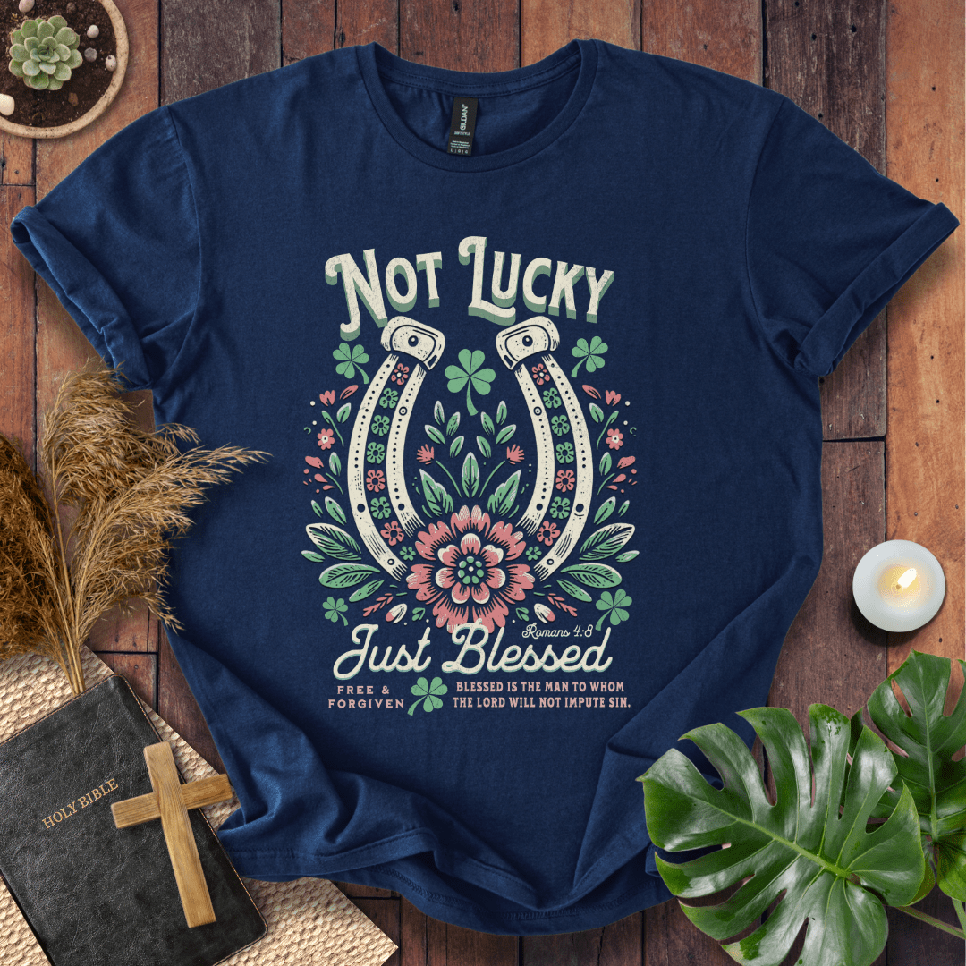 “Not Lucky, Just Blessed” Romans 4:8 Christian t-shirt with twin horseshoes, clovers, and florals; western faith tee.