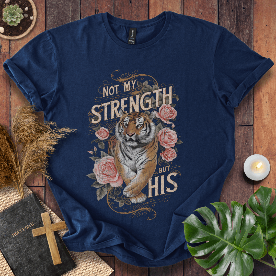 Not My Strength But His Christian t-shirt in black—tiger with roses and vintage script faith design.