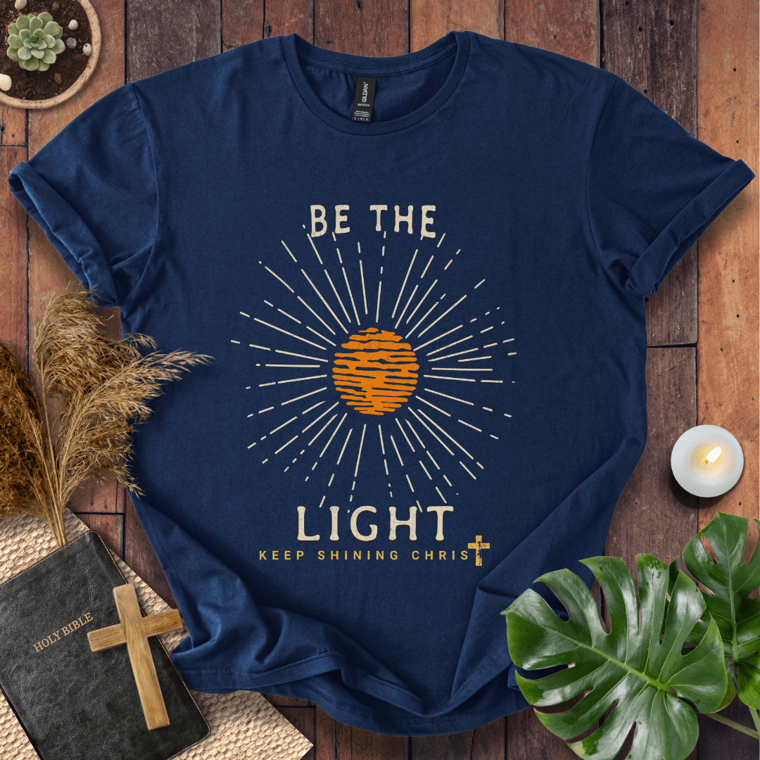 Be the Light Christian t-shirt—radiant sunburst with “Keep Shining Christ,” inspired by Matthew 5:14–16.