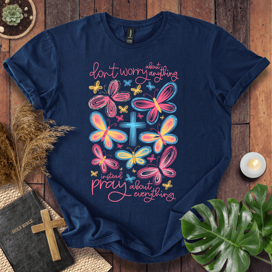 butterfly faith shirt with a Bible and cross on a rustic wooden background.