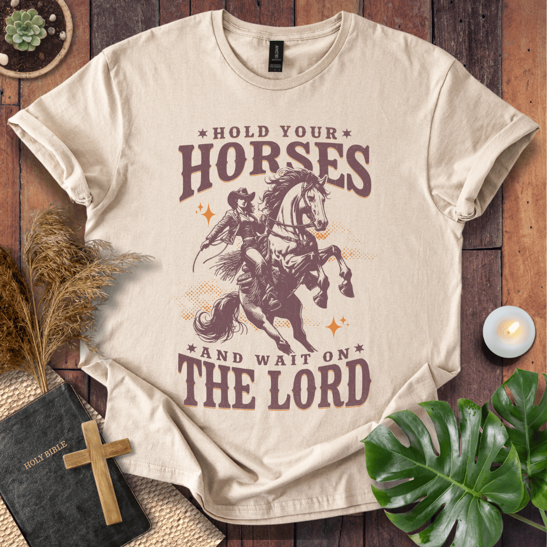 Cowgirl riding a rearing horse on a t-shirt with text saying Hold Your Horses and Wait on the Lord.