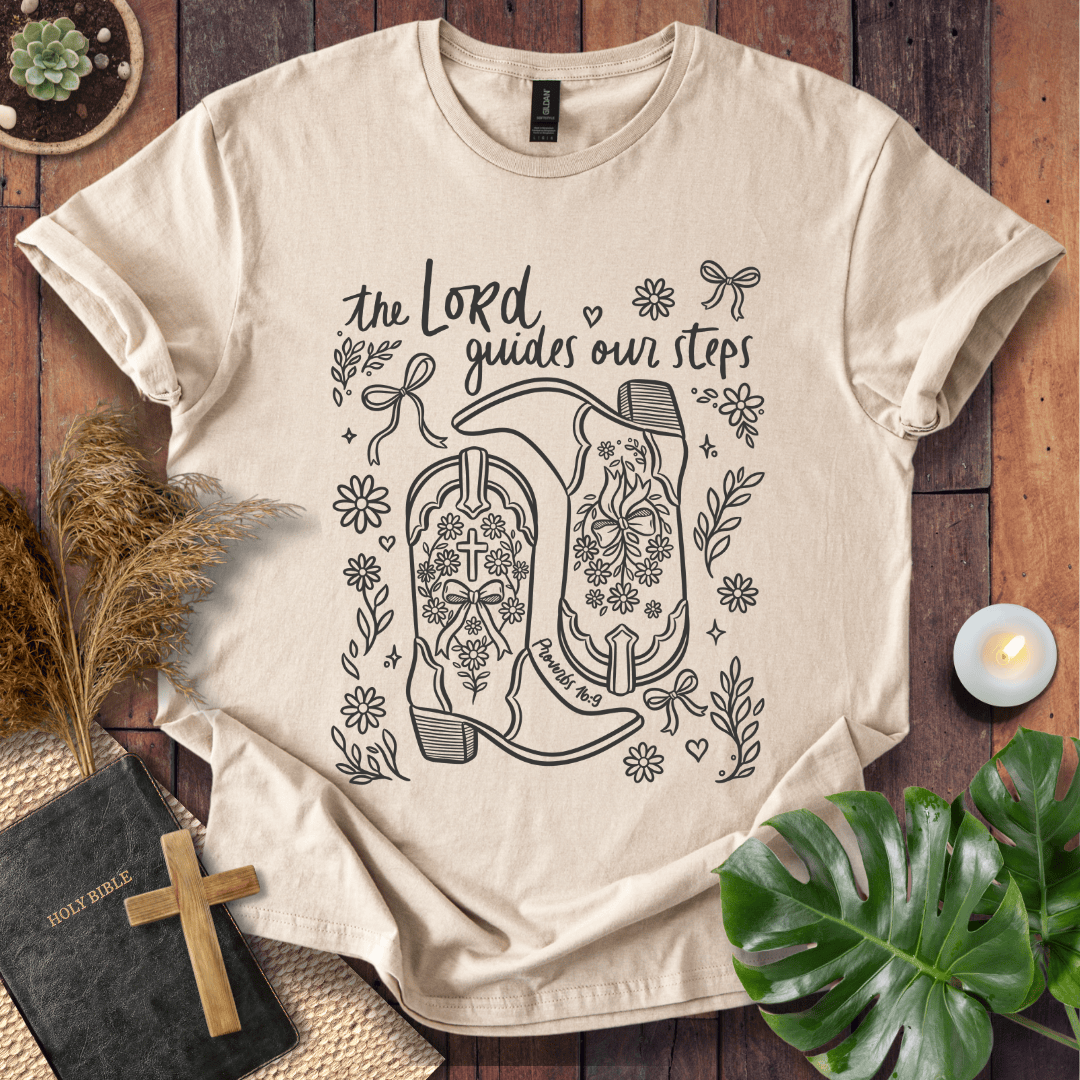 Line art cowboy boots with flowers and bows on a t shirt featuring Proverbs 16:9 "The Lord guides our steps."