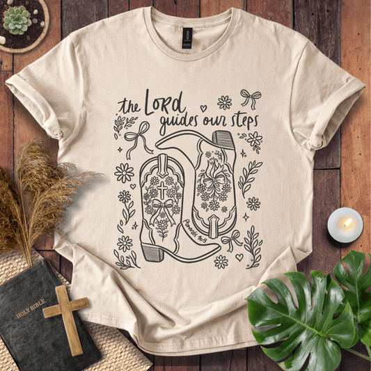 Line art cowboy boots with flowers and bows on a t shirt featuring Proverbs 16:9 "The Lord guides our steps."