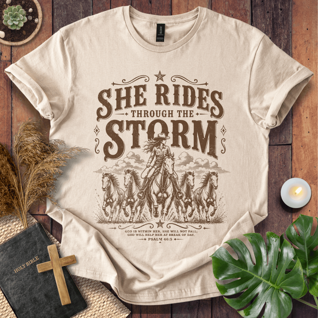 country t-shirt featuring a cowgirl riding a horse with the scripture text She Rides Through the Storm Psalm 46:5.