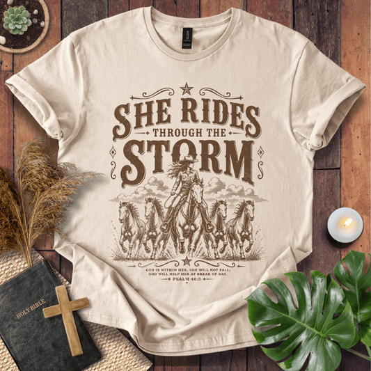 country t-shirt featuring a cowgirl riding a horse with the scripture text She Rides Through the Storm Psalm 46:5.