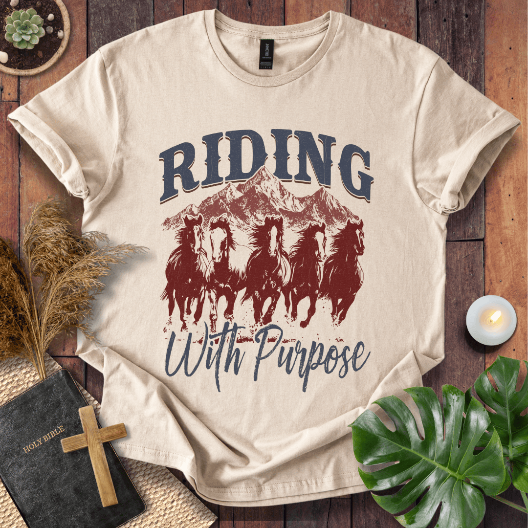 t-shirt with navy and rust graphic of five running horses, mountains, and "Riding With Purpose" vintage text.