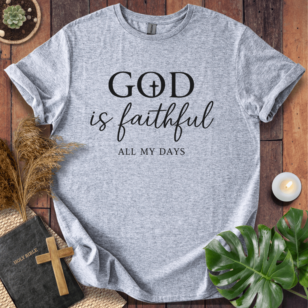 Christian t-shirt reading "God is Faithful All My Days" on a rustic wood background with a Bible and cross.