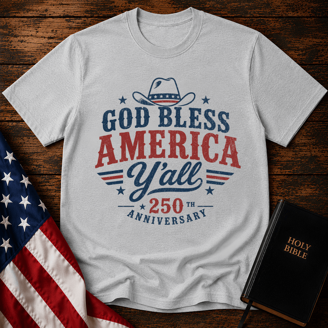 Christian t shirts featuring a Western cowboy hat, USA flag details, and God Bless America Y'all text on wood.