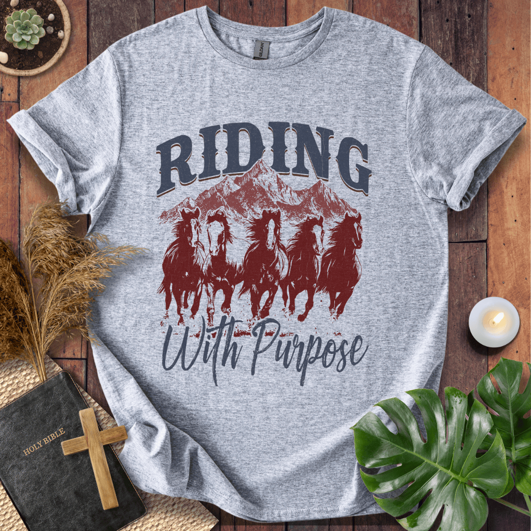 t-shirt with navy and rust graphic of five running horses, mountains, and "Riding With Purpose" vintage text.