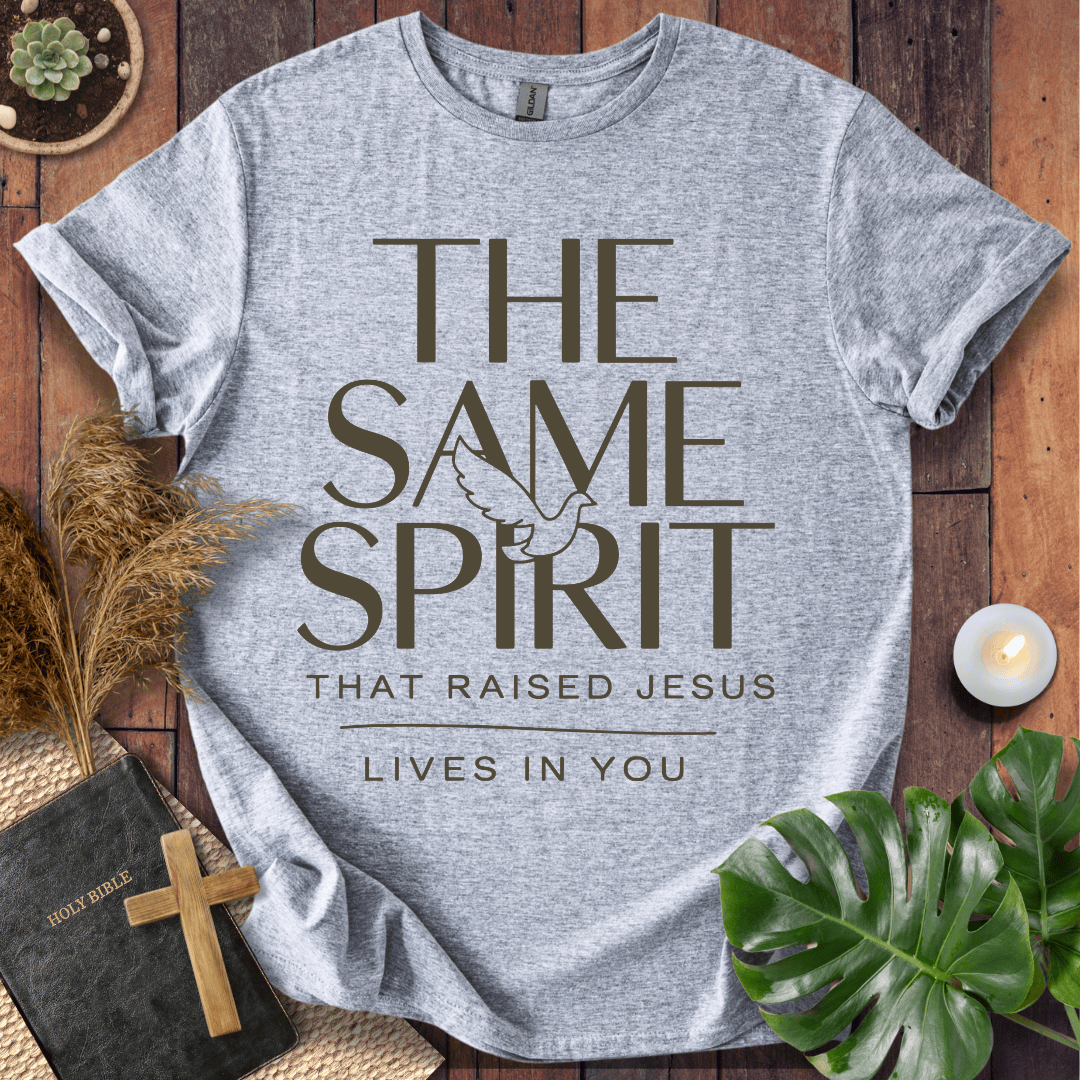 Easter Christian t-shirt with "The Same Spirit That Raised Jesus Lives In You" text and dove icon on wooden background.