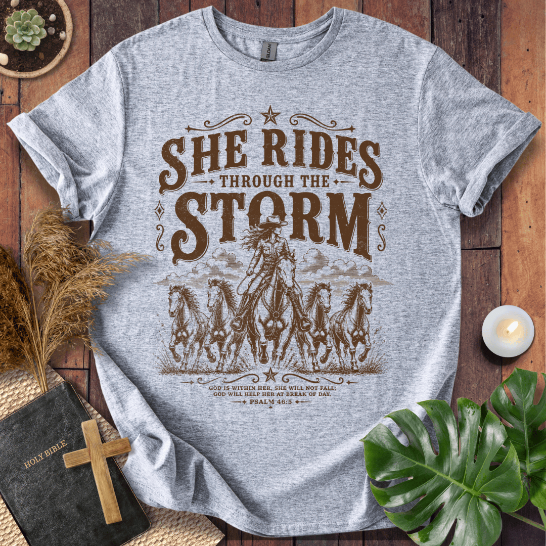 country t-shirt featuring a cowgirl riding a horse with the scripture text She Rides Through the Storm Psalm 46:5.