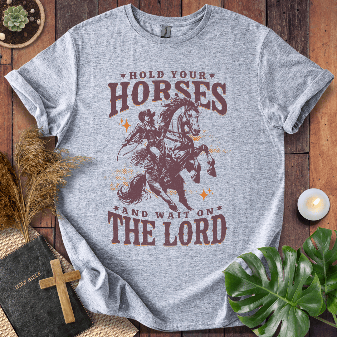 Cowgirl riding a rearing horse on a t-shirt with text saying Hold Your Horses and Wait on the Lord.