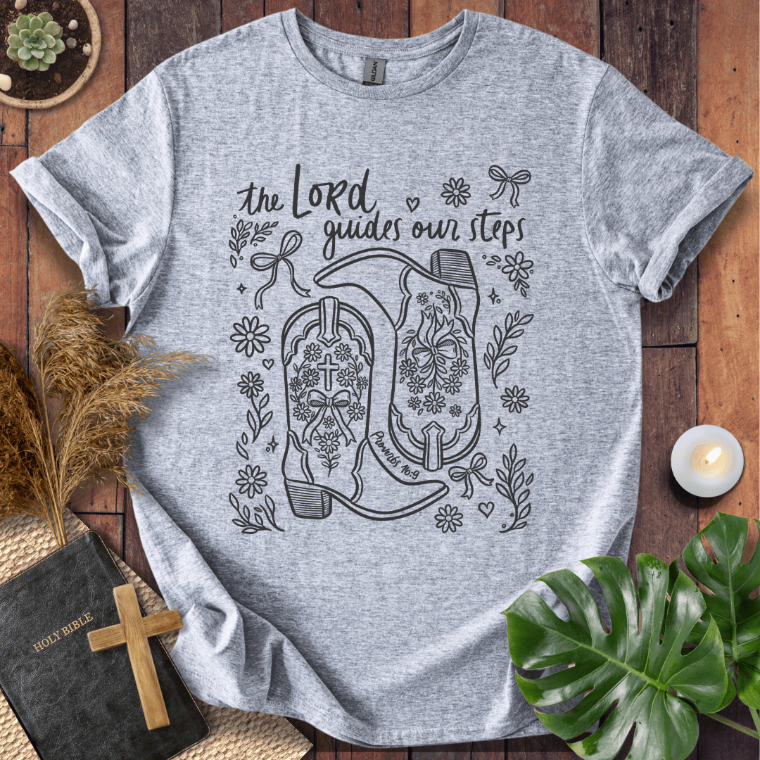Line art cowboy boots with flowers and bows on a t shirt featuring Proverbs 16:9 "The Lord guides our steps."