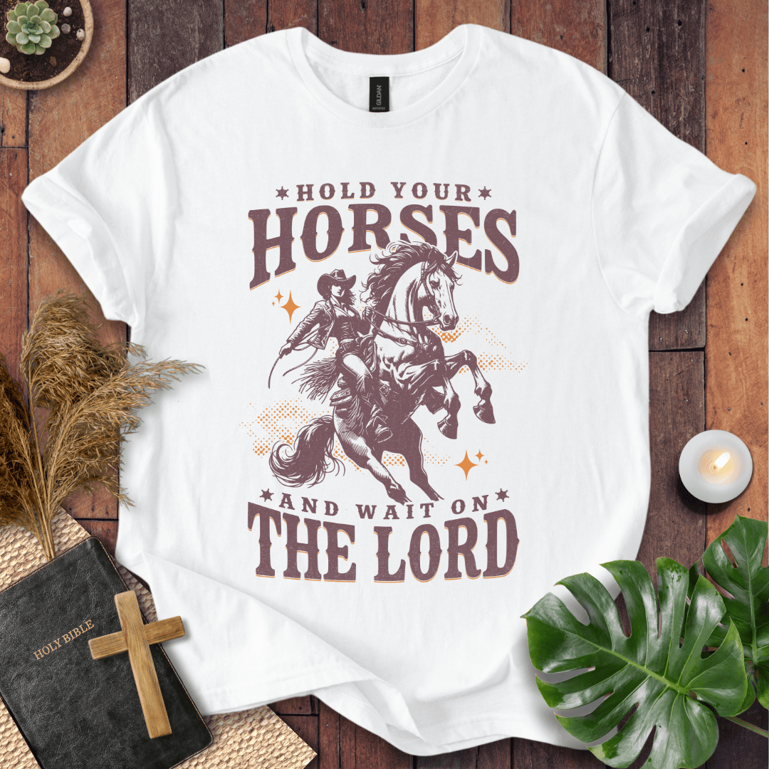 Cowgirl riding a rearing horse on a t-shirt with text saying Hold Your Horses and Wait on the Lord.