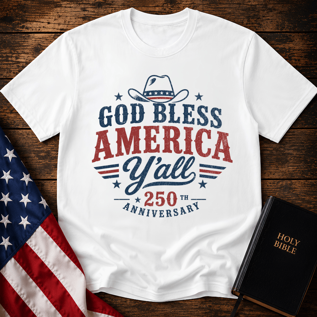 Christian t shirts featuring a Western cowboy hat, USA flag details, and God Bless America Y'all text on wood.