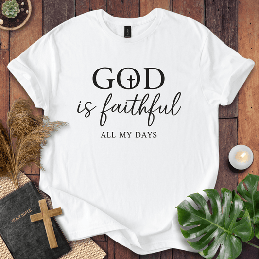 Christian t-shirt reading "God is Faithful All My Days" on a rustic wood background with a Bible and cross.