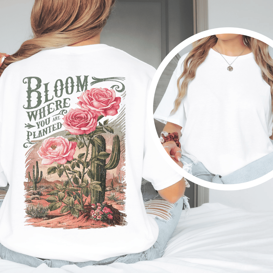 Back of a t-shirt featuring pink roses, green saguaro cacti, and text reading Bloom Where You Are Planted.