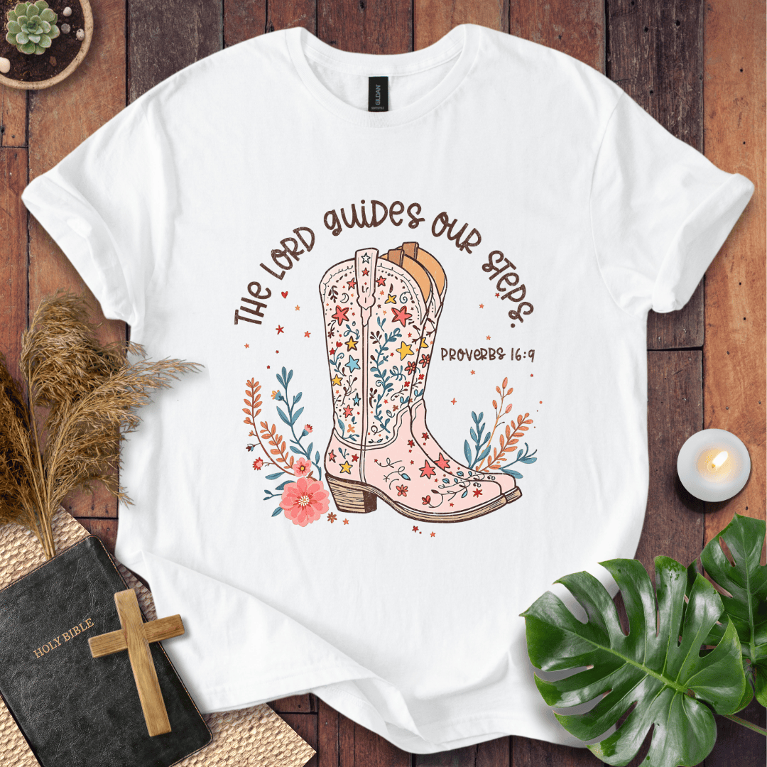 Christian t-shirt featuring a floral cowboy boot and the text The Lord Guides Our Steps Proverbs 16:9 in a rustic font.