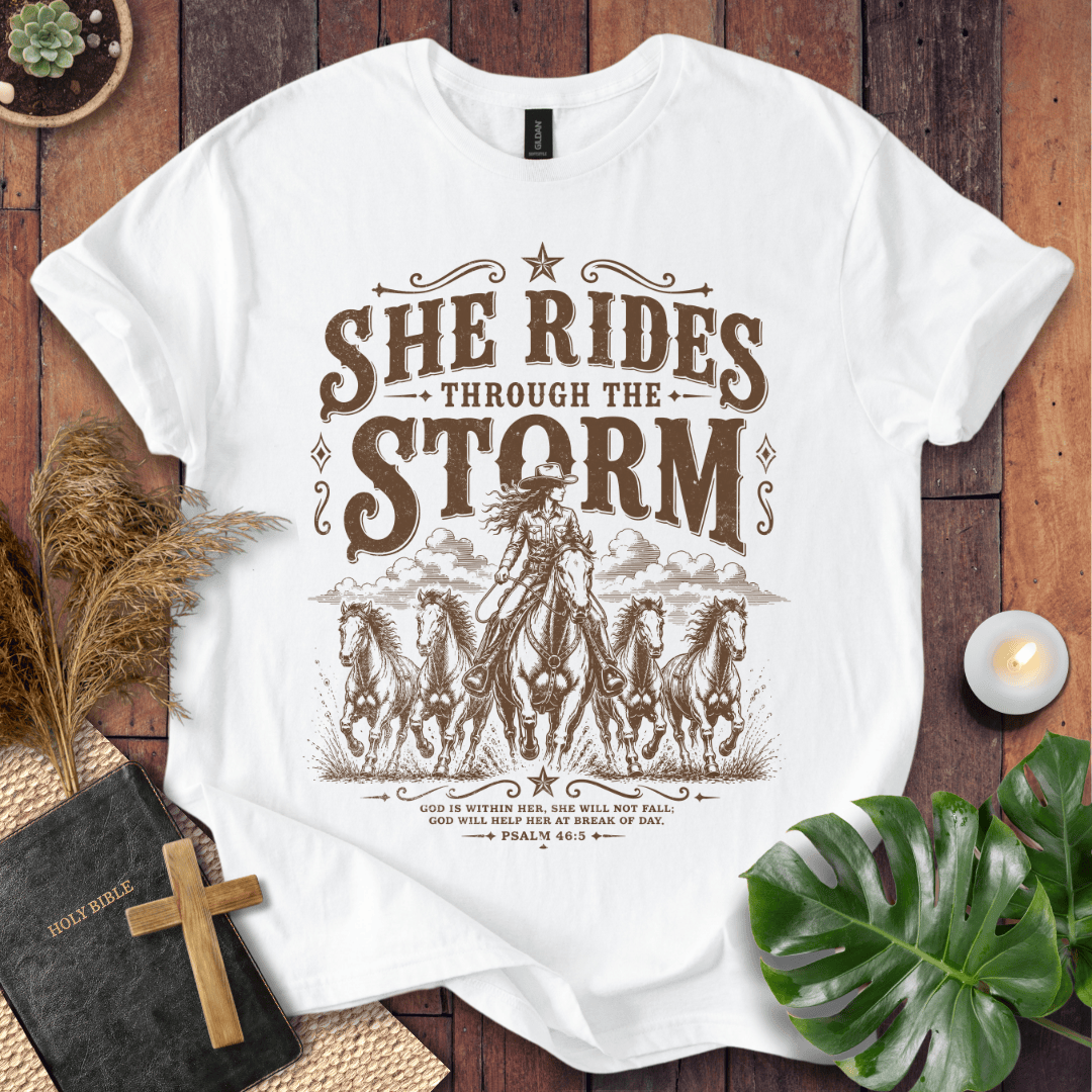 country t-shirt featuring a cowgirl riding a horse with the scripture text She Rides Through the Storm Psalm 46:5.